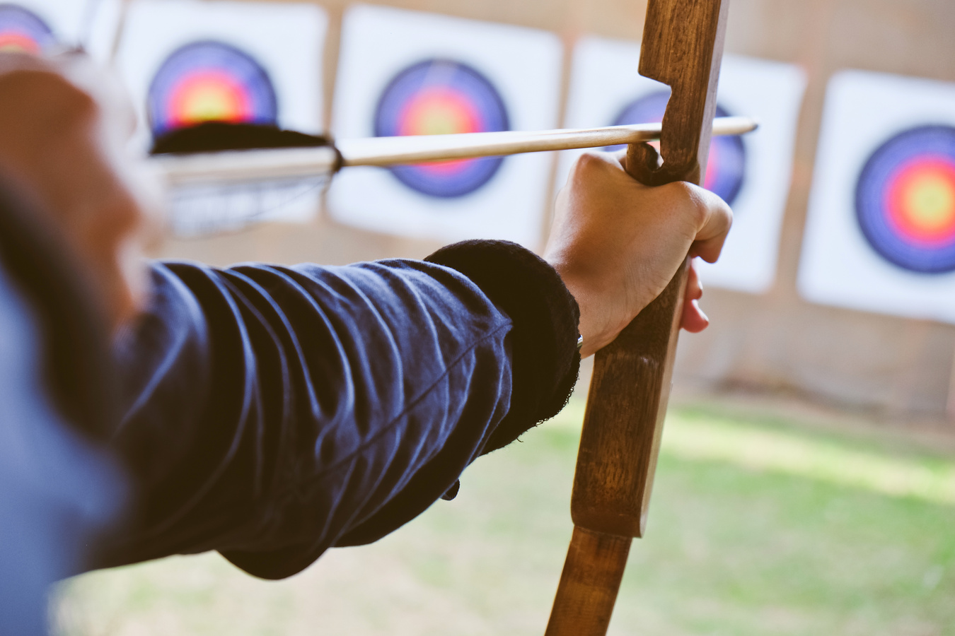 Archer holds his bow aiming at a target